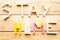 Phrase Stay at Home from toy constructor on wooden background.