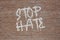 Phrase Stop Hate spray painted in white on a brick wall