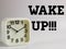 Phrase wake up with alarm clock isolated on white background.