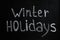 Phrase Winter Holidays written on black chalkboard