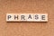 PHRASE word written on wood block.