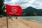 Phuket, Thailand - December 4, 2019: No swimming here sign on red flag at the Kamala Beach, Phuket