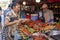 Phuket, Thailand, January 8, 2020: A woman chooses the best pieces of fried chicken from a fast food street vendor in the market