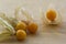 Physalis peruviana edible tasty physalis orange yellow fruits in dry husks on creased paper on the table