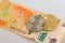 Physical Bitcoin and Ethereum coin over a thousand argentinian pesos bill on white background. Cryptocurrency exchange,