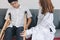 Physical female doctor helping patient with crutches in hospital office