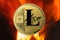 Physical Litecoin gold coin LTC with fire or flame background