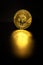 Physical shiny bitcoin agains dark background