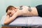 Physical therapist positioning electrodes for back muscle treatment young man