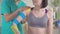 Physical therapist in uniform sticks Kinesiotape on patient`s shoulder