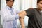 Physical therapists press to the patient shoulder check for pain