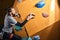 Physically challenged man climbing on artificial colourful rock wall