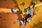 Physically challenged man stuck at difficult rock wall in bouldering gym