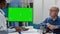 Physician and elderly man in wheelchair analyzing greenscreen