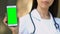 Physician holding green screen smartphone in hand, online registration to doctor