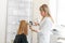 Physician trichologist dermatologist examines the state of the patient`s hair and hair roots with a dermatoscope