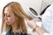 Physician trichologist dermatologist examines the state of the patient`s hair and hair roots with a dermatoscope