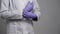 Physician is wearing rubber protective gloves on hands in office of medical clinic, detail view on palms