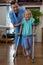 Physiotherapist assisting girl patient to walk with crutches