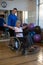 Physiotherapist assisting senior woman on wheelchair with dumbbells