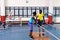 Physiotherapist helping disabled man walk with parallel bars in sports center