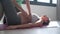 Physiotherapist helping to beautiful pregnant woman for doing pilates exercises with ball preparing for childbirth.