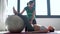 Physiotherapist helping to beautiful pregnant woman for doing pilates exercises with ball preparing for childbirth.