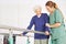 Physiotherapist helping woman on treadmill