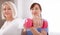 A physiotherapist helps an older woman recover from an injury through exercise with dumbbells.