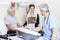 Physiotherapist Holding Clipboard While Colleague And Patient Si