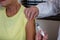 Physiotherapist injecting senior patient