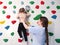 physiotherapist instructor helping little girl to climb wall in gym. sensory integration for kid and correctional