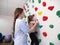 physiotherapist instructor helping little girl to climb wall in gym. sensory integration for kid and correctional