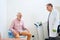 Physiotherapist performs effective pelvic floor stimulation procedure on old man