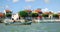 Piacabucu/Alagoas/Brazil - Apr.13.19: boats on river, roofs, houses and trees of the coast town. people seated under the shadow