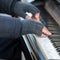 The pianist plays the piano outside in winter.