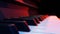 Piano keyboard in red and blue light close-up forward panning.