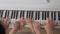 Piano keyboard top view hands of mother and children playing music. Family unity concept.