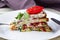 Pice of zucchini cake with tomatoes and fresh parsley on white wooden background