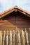 Picket wooden sharp fence closeup. Background blurred roof