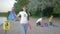 Picking garbage, portrait of young volunteer mom in rubber gloves with trash bag near pointer sign on background dad