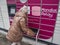 Picking up a parcel from a Mondial Relay locker by a young woman. Lockers Mondial Relay. Pickup box to send and receive parcels.