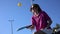 Pickle ball player juggling with a perforated plastic ball and a racket