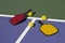 Pickleball - colorful paddles, ball and court