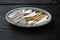 Pickled Anchovy, in plastic container, on black wooden table background