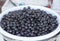 Pickled black olives in bucket close-up. It was filmed in front of a shop.
