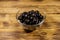 Pickled black olives in glass bowl on wooden table