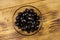 Pickled black olives in glass bowl on wooden table