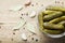 Pickled gherkins or cucumbers in bowl on wooden rustic table.