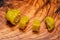 Pickled Golden Greek Peppers, Pepperoncini or Friggitelli sweet Italian chili pepper on natural olive wood cutting board .